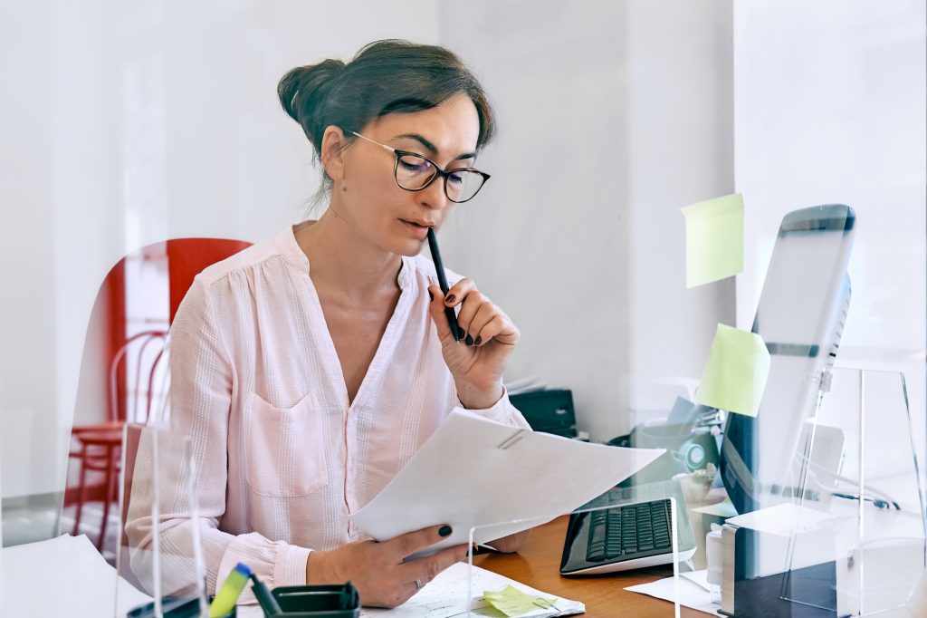 Attentive female bookkeeper check accounts bills.