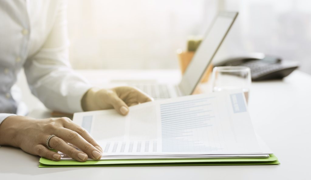 Businesswoman checking financial reports and statements