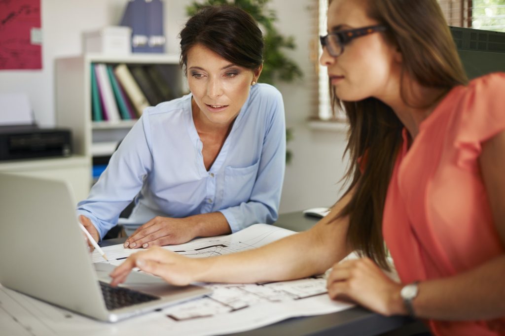 Two women consulting data on the computer